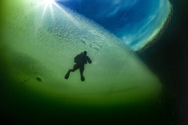 Austria, Styria, Lake Grundlsee, scuba diver under ice floe - YRF00165