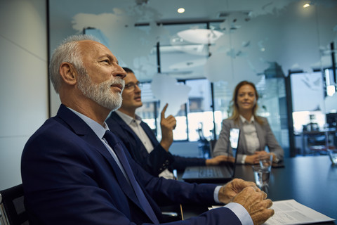Portrait of senior businessman listening in a meeting stock photo