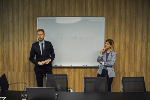 Geschäftsmann und Geschäftsfrau führen eine Präsentation im Sitzungssaal - ZEDF00917