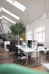 Desks with PCs in bright and modern open space office - FKF02620