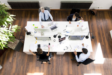 Geschäftsleute in einem Planungsbüro, die am Schreibtisch sitzen und zusammenarbeiten - FKF02628