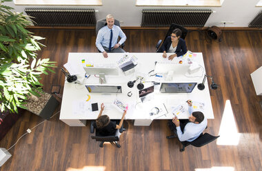 Business people in planning office sitting at desk, working together - FKF02630