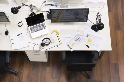 Schreibtische mit PCs in einem hellen und modernen Großraumbüro, lizenzfreies Stockfoto