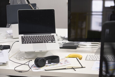 Laptop mit Kopfhörern auf dem Schreibtisch - FKF02724