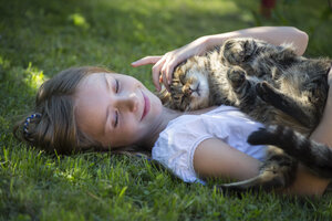 Mädchen liegend mit Katze im Garten - SARF03392