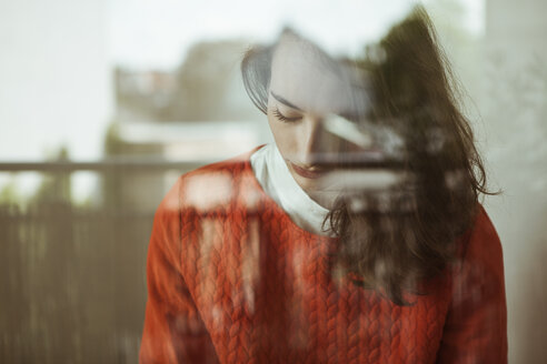 Serious young woman behind glass pane - FEXF00290