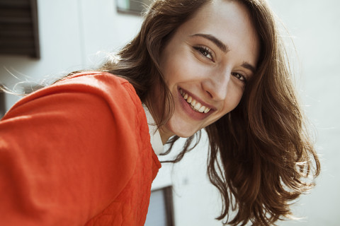 Portrait of smiling young woman on balcony stock photo