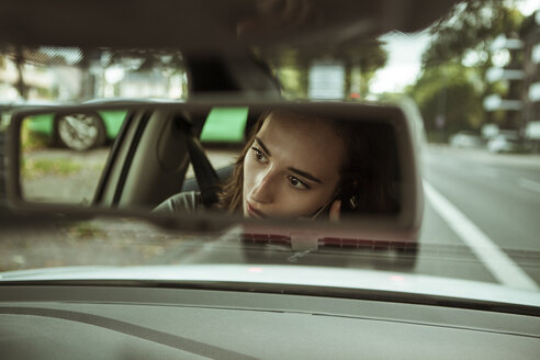 Spiegelbild einer jungen Frau im Auto, die telefoniert - FEXF00301