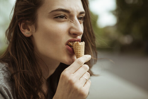 Junge Frau isst eine Eistüte im Freien - FEXF00303