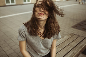 Junge Frau im Freien mit vom Wind zerzaustem Haar - FEXF00304