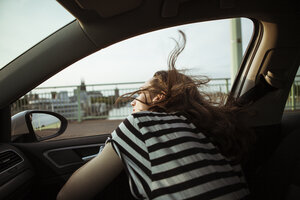 Young woman leaning out of car window - FEXF00311