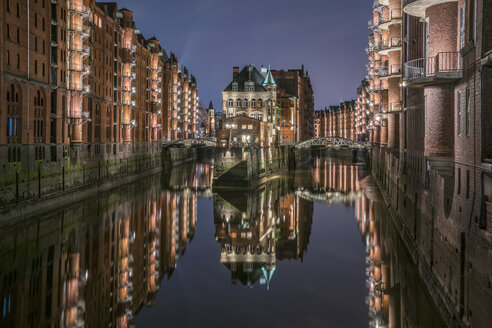 Deutschland, Hamburg, Speicherstadt, beleuchtete Altbauten mit Elbphilharmonie im Hintergrund - PVCF01103