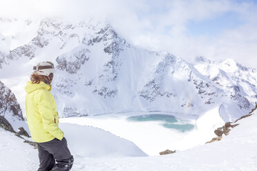 Austria, Kuehtai, woman with ski helmet at Finstertal reservoir - MMAF00161
