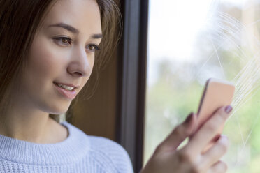 Junge Frau überprüft ihr Smartphone im Zug - MMAF00172