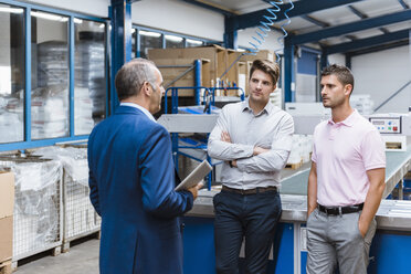 Geschäftsleute bei einer Besprechung in der Fabrikhalle eines Unternehmens - DIGF02971