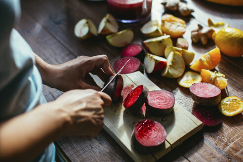 Woman's hands chopping beetroot for squeezing juice - MOMF00279