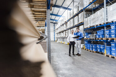 Two businessmen having a meeting in company warehouse - DIGF02992