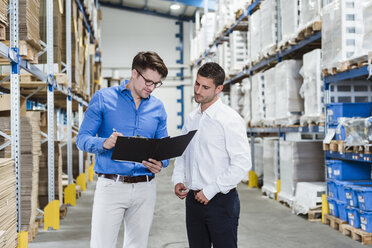 Two businessmen having a meeting in company warehouse - DIGF02994