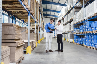 Two businessmen having a meeting in company warehouse - DIGF02995