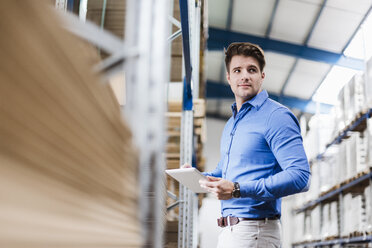 Young man working in warehouse, using digital tablet - DIGF03002