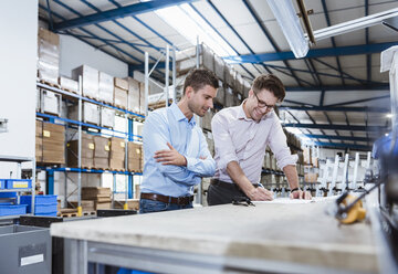 Business people standing on shop floor, discussing product improvement - DIGF03024