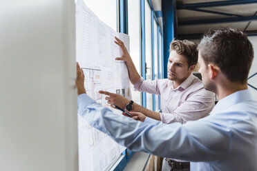 Business people standing t window, discussing production plans - DIGF03027