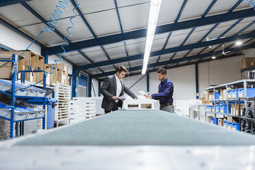 Business people standing on shop floor, discussing product improvement - DIGF03032