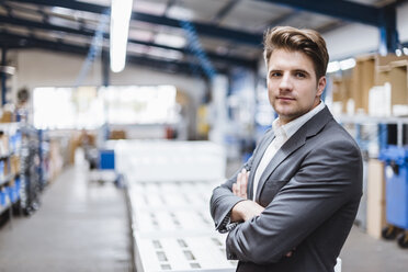 Young manager standing in shop floor, portrait - DIGF03038