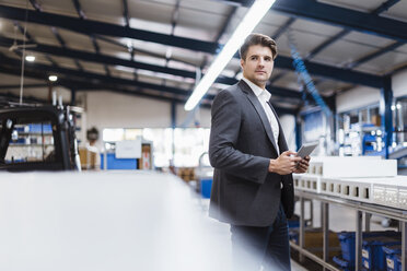 Young manager standing in shop floor with digital tablet, portrait - DIGF03040