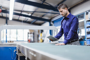 Geschäftsmann bei der Arbeit in der Werkstatt, mit digitalem Tablet - DIGF03042