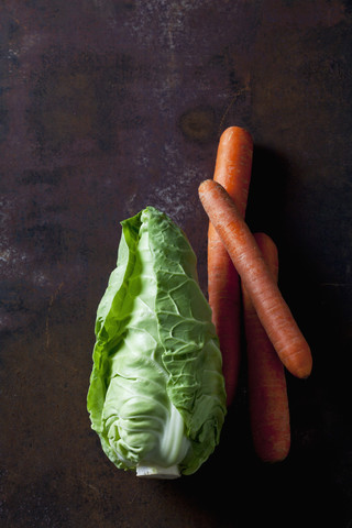 Süßer Kohl und Karotten auf dunklem Hintergrund, lizenzfreies Stockfoto