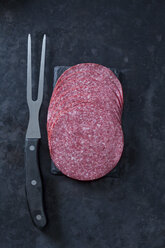 Salamiwurst in Scheiben geschnitten mit Fleischgabel - CSF28451