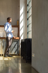 Young entrepreneur standing in company kitchen, drinking coffee - SPCF00212