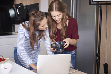 Bloggers looking at images on digital camera - ABIF00031