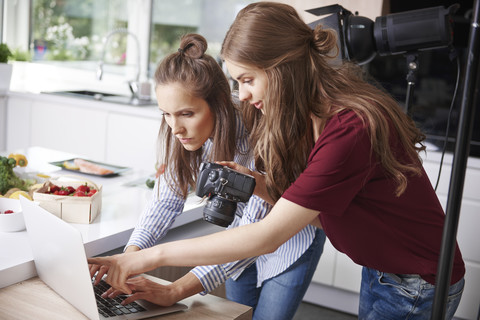 Blogger mit Laptop und Kamera in der Küche, lizenzfreies Stockfoto