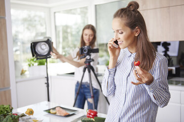 Woman talking on the phone and eating strawberry - ABIF00037