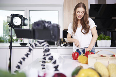 Woman recording while chopping vegetables - ABIF00047