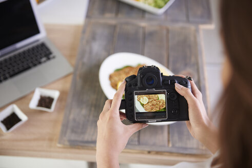 Nahaufnahme einer Frau beim Fotografieren von gebratenem Fisch - ABIF00061