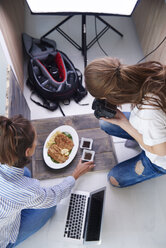 Woman styling prepared dish during photo session - ABIF00063