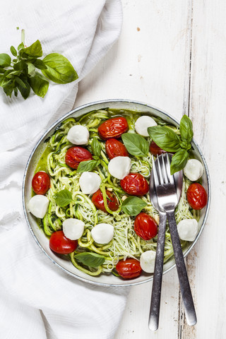 Zoodles Caprese, spiralisierte Zucchini, Glasnudeln, Pesto, Pflaumentomaten, Mozarellakugeln, lizenzfreies Stockfoto