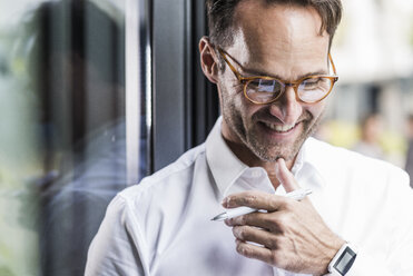 Porträt eines lachenden Geschäftsmannes mit Brille und Smartwatch - UUF12063