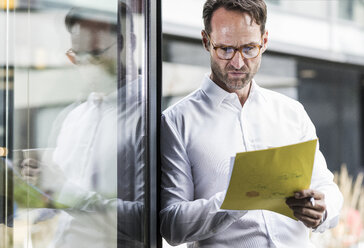 Businessman checking papers - UUF12065