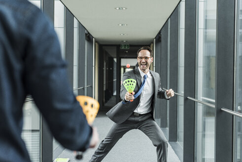 Businessman playing with colleague on the corridor - UUF12102