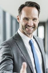 Portrait of smiling businessman shaking hands - UUF12105