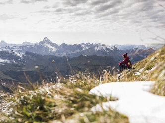 Germany, Bavaria, Oberstdorf, hiker sitting in alpine scenery - UUF12131