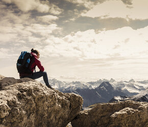 Germany, Bavaria, Oberstdorf, woman sitting on rock in alpine scenery - UUF12152