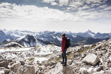 Germany, Bavaria, Oberstdorf, woman standing on rock in alpine scenery - UUF12153