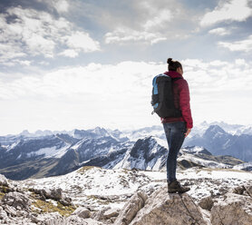 Deutschland, Bayern, Oberstdorf, Frau steht auf Felsen in alpiner Landschaft - UUF12154