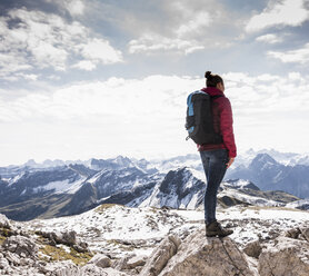 Germany, Bavaria, Oberstdorf, woman standing on rock in alpine scenery - UUF12154