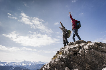 Deutschland, Bayern, Oberstdorf, zwei Wanderer jubeln am Felsen in alpiner Kulisse - UUF12158